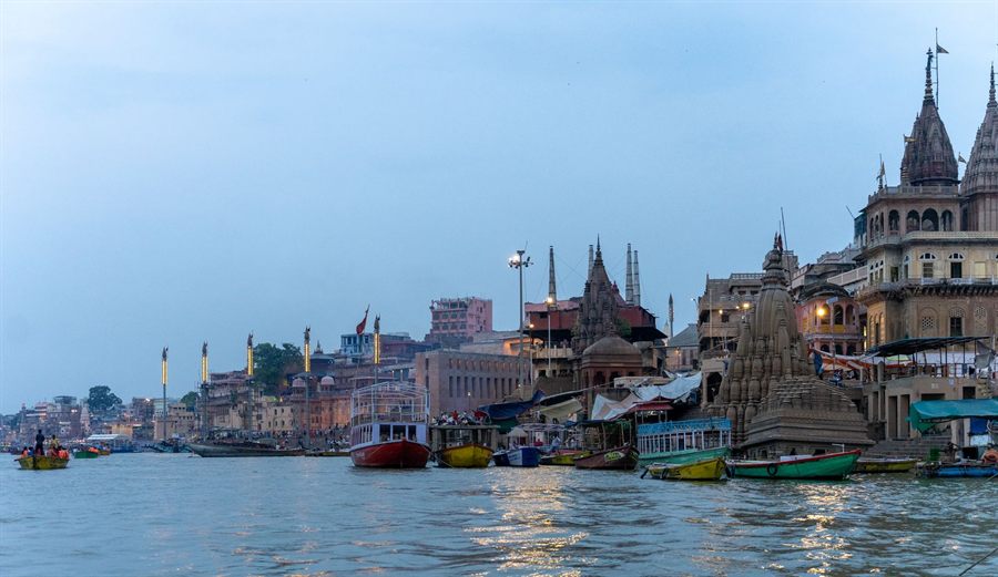 Ghats and temples along the Ganges at Varanasi, India, with boats at the water&rsquo;s edge